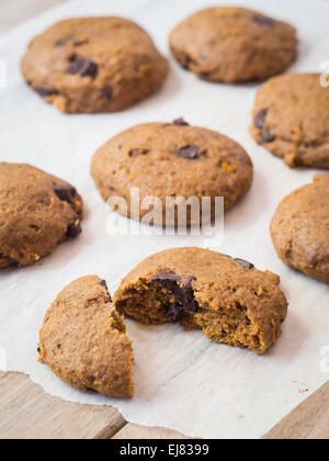 Weiche Vollkorn Vegan Dinkel Kürbis Cookies mit Schokolade-Chips auf ein Stück Backpapier. Stockfoto