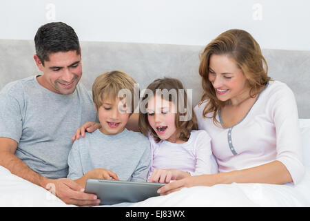 Familie mit Hilfe von digital-Tablette im Bett Stockfoto
