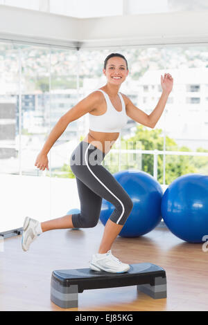 Junge Frau darstellende Step Aerobicsübung passen Stockfoto