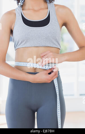 Innenfeldes von einer sportlichen Frau messen Taille im Fitness-studio Stockfoto