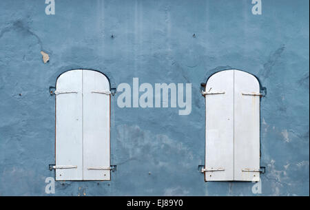 Alte Fensterläden über Windows auf einer Grunge-Wand Stockfoto