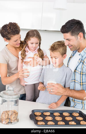 Fröhliche Familie mit Cookies und Milch Stockfoto