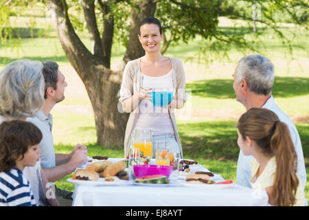 Großfamilie mit Mittagessen in Rasen Stockfoto