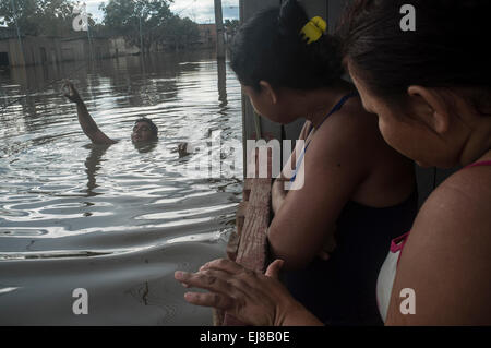 2015 Überschwemmungen im brasilianischen Amazonas - überfluteten Haus in Taquari Bezirk, Rio Branco Stadt, Bundesstaat Acre. Jose Alcides Dos Santos im Dunkeln und Schmutz Wasser des Hektar großen Fluss neben seinem Haus schwimmt, während seine Familie auf dem Balkon wartet. Überschwemmungen haben Tausende von Menschen im Bundesstaat Acre, Nordbrasilien, seit 23. Februar 2015, betroffen worden als einige der Flüsse des Landes, insbesondere Flusses Acre übergelaufen. Stockfoto