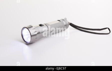 graue Taschenlampe über einen grauen Hintergrund auf dem Boden Stockfoto