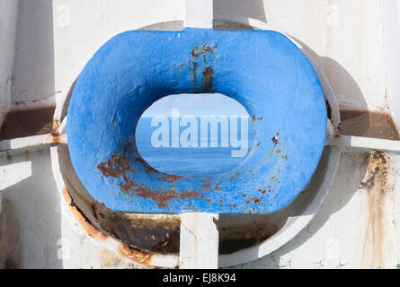 Blaue Schleife Hawse in alten weißen rostige Schiffsrumpf mit Meer-Landschaft im Inneren Stockfoto