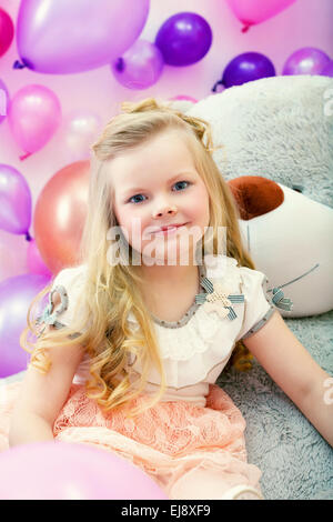 Lächelnd, kleine blonde posiert mit großen Spielzeug Stockfoto