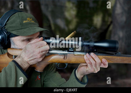 Ältere Jäger mit Mauser Bolt Action Riffle, die aus leeren Aufzählungszeichen Gehäuse beim wiederholen/Nachladen der Waffe einsetzt, Stockfoto