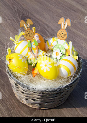 glückliche Kaninchen mit Ostereiern in einem Korb Stockfoto