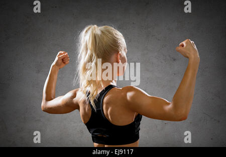 sportliche Frau von hinten Biegen ihren Bizeps Stockfoto