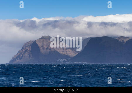 Die Küste von La Gomera vom Meer mit Wolken über das Land mit Stadt von Valle Gran Rey im Blick Stockfoto
