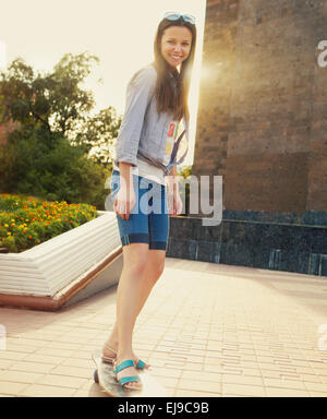 Teengirl auf Longboard auf der Straße Stockfoto