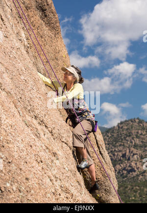 Ältere Dame auf steilen Felsen klettern in Colorado Stockfoto