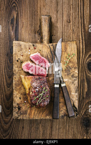 Steak auf dem alten Holzbrett Stockfoto