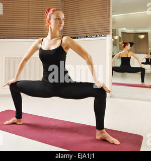 Rothaarige in Yoga-Pose stehen Stockfoto