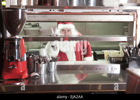 Santa Claus lächelnd in Undustrial Küche Stockfoto