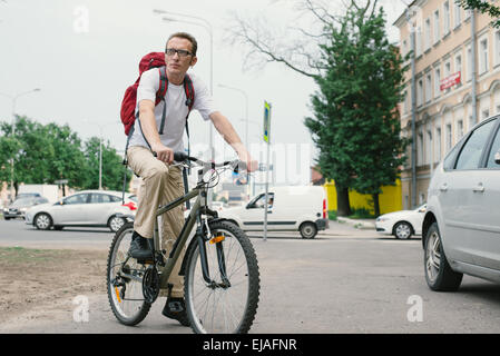 Mann am Fahrrad auf moderne Straße Stockfoto