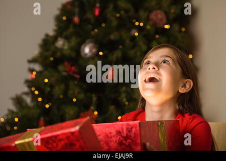 Kleines Mädchen öffnen ein magisches Weihnachtsgeschenk Stockfoto