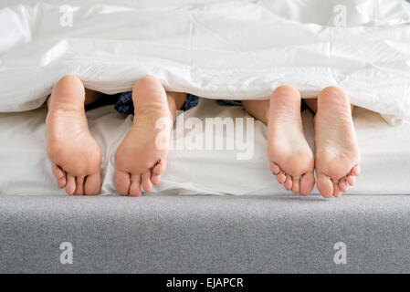 Süße Paare Fußsohlen auf Bett Stockfoto