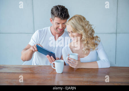 Mann zeigt seine Frau etwas auf einem tablet Stockfoto