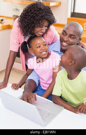 Glückliche Familie mit dem Laptop zusammen Stockfoto