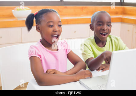 Niedlichen Geschwister mit Laptop zusammen Stockfoto