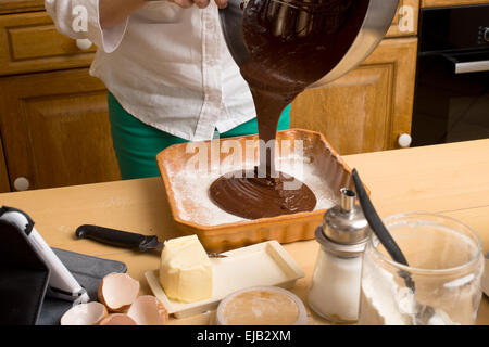 Frau Hände in eine Form gießen geschmolzenen Schokolade Stockfoto