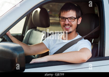 Männlichen kaukasischer guter Fahrer lächelt in seinem Auto Stockfoto