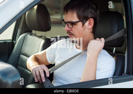 Männlichen europäischen Fahrer nutzt Sicherheitsgurt im Auto Stockfoto