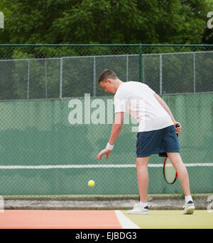 Junge Tennisspieler zu dienen Stockfoto