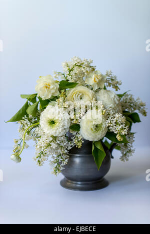 Frühling-Blumen-Arrangement mit weißen Ranunkeln und lila Blüten Stockfoto