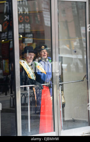 Zwei ältere Menschen schauen Sie durch eine Glastür die 2013 St. Patricks Day Parade in Newark, New Jersey. USA. Stockfoto