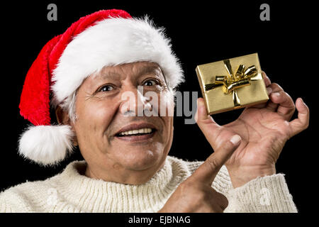 Alter Mann mit emphatischen Look und goldenen Geschenk Stockfoto