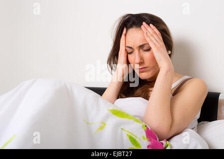 junge Frau zu Hause leiden unter Kopfschmerzen Stockfoto