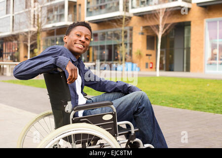 ein glücklicher junger Mann im Rollstuhl. Stockfoto