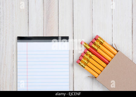 Eine Schachtel mit gelben Bleistifte mit einem roten Stift teilweise herausgezogen. Die einfache braunen Box ist in der unteren rechten Ecke des Rahmens Stockfoto