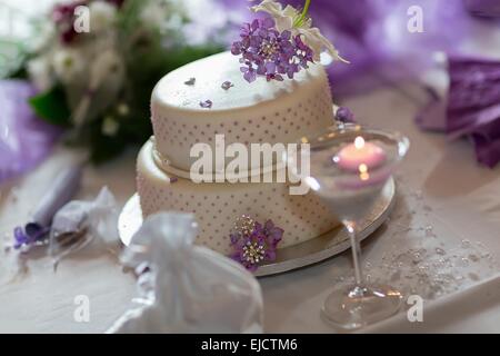Traditionelle Hochzeitstorte mit lila Blüten Stockfoto