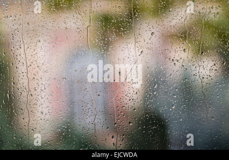 Regentropfen auf Fenster mit farbigen Hintergrund Stockfoto