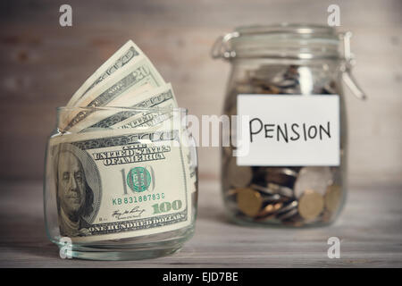 Dollar und Münzen in Glas jar mit Pension Label, Finanzkonzept. Vintage-Ton aus Holz Hintergrund mit dramatischen Licht. Stockfoto