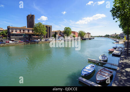 Kleine Boote vertäut am Fluss Hérault übersehen von Agde Kathedrale in der Stadt Agde, Herault, Languedoc-Roussillon, Frankreich Stockfoto