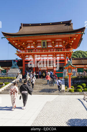 Traditionell gekleidete japanisches Paar zu Fuß in Richtung der Turmtor am Fushimi Inari Schrein, Kyoto, Japan Stockfoto