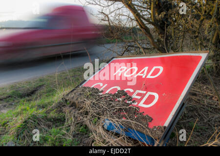 Geschlossen Schild links an einem Straßenrand mit einem Fahrzeug mit Geschwindigkeit geleitet Stockfoto