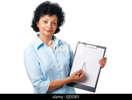 Ältere Frau hält eine Zwischenablage und zeigt etwas über weiß. Stockfoto