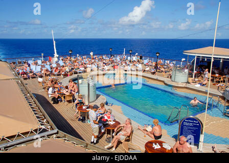 Passagiere, entspannen in der Sonne am Pool auf Kreuzfahrtschiff auf hoher See Stockfoto