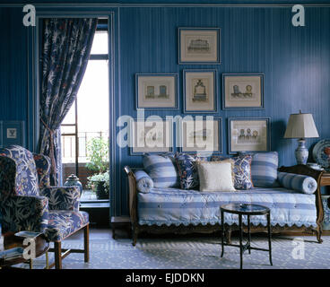 Blaue Blumen Vorhang auf Fenstertüren in eleganten blauen Salon mit gestreiften Deckel auf französischen Stil sofa Stockfoto