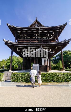 Touristen auf der Suche auf Beschilderung vor dem Haupttor im Tempel Tofuku-Ji, Kyoto, Japan Stockfoto