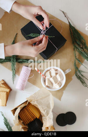 Eine Person einwickeln ein Paket und ein Glas hausgemachte Marshmallows. Stockfoto