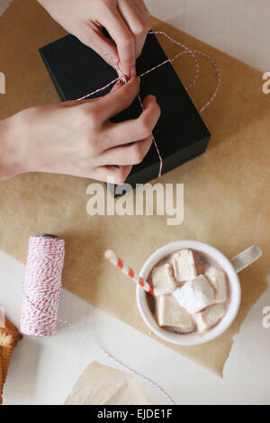 Eine Person einwickeln ein Paket und ein Glas hausgemachte Marshmallows. Stockfoto