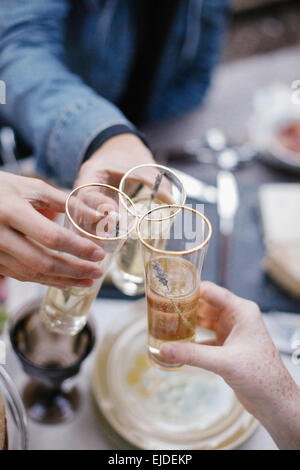 Drei Menschen, die einen Toast, Gläser klirren. Stockfoto