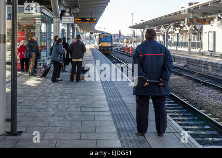 Train Dispatcher und die Menschen warten auf einen Zug am Bahnhof Derby, England, Großbritannien anreisen Stockfoto